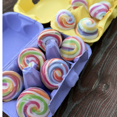 A 6-egg purple pulp egg carton used for candy packaging. There is a yellow paper pulp carton in the background